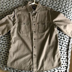 Button-down solid gray twill shirt. Two buttoned breast pockets and epaulets.